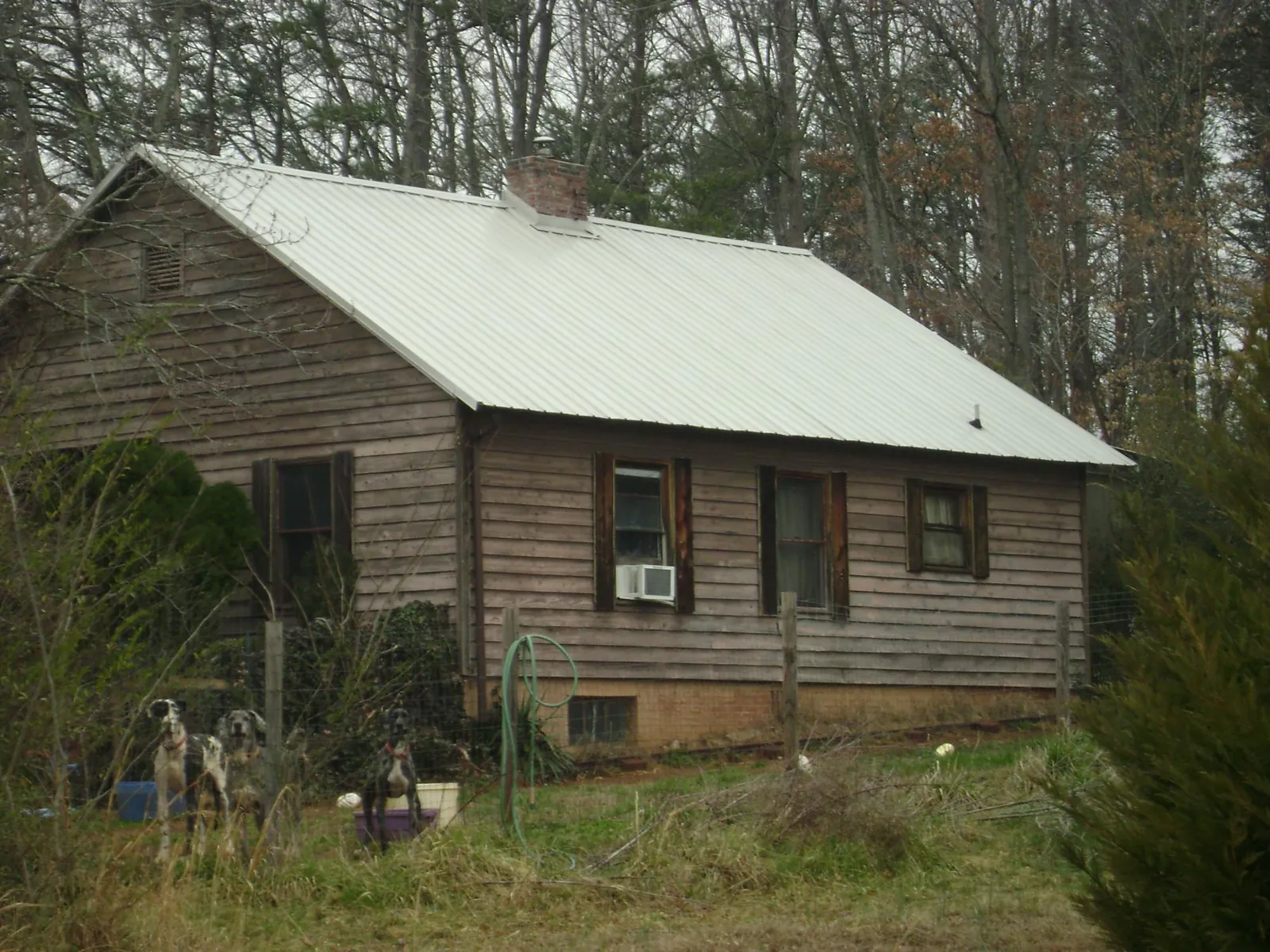 White metal roof on an old wood sided farmhouse, from a Metal Roof Installation job in Holly Springs